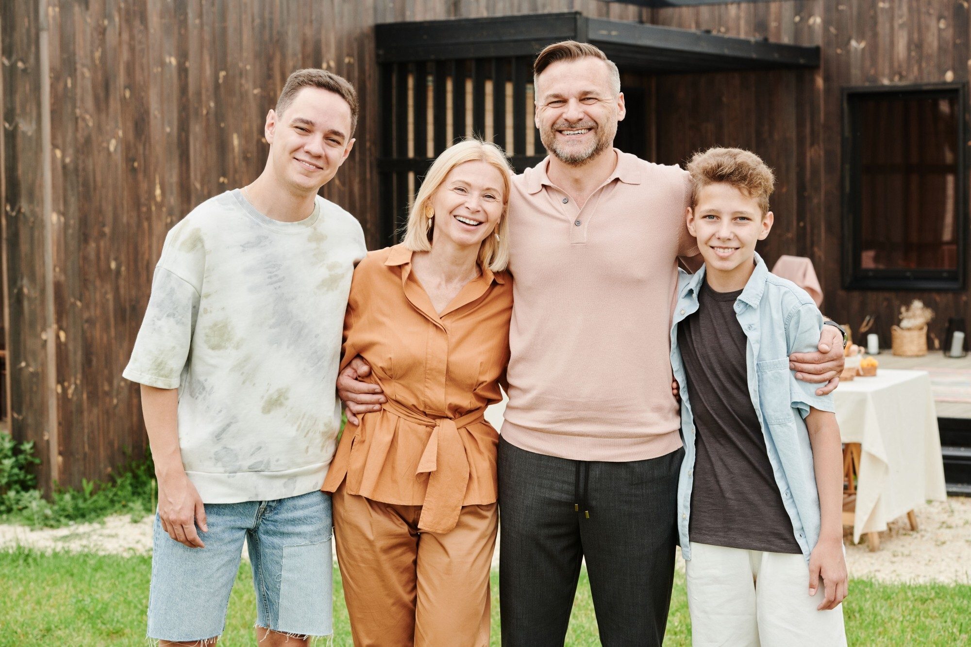 A smiling family of four together in their backyard